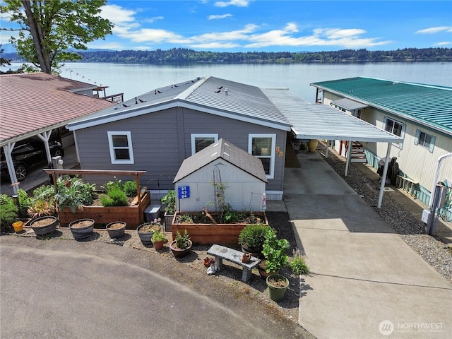 4805 Cushman Rd NE Unit 61, Olympia, WA 98506 - view of front of property with a carport, concrete driveway, a garden, and a water view