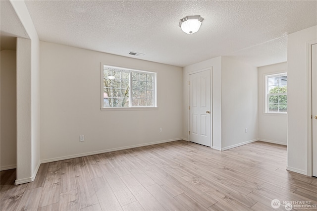 30521 NE 147th Ct, Battle Ground, WA 98604 - empty room with plenty of natural light, light wood-type flooring, a textured ceiling, and baseboards