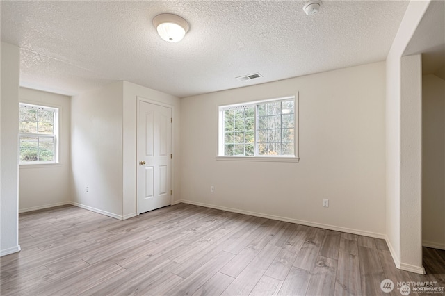 30521 NE 147th Ct, Battle Ground, WA 98604 - empty room with plenty of natural light, wood finished floors, a smoke detector, a textured ceiling, and baseboards