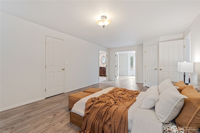 30521 NE 147th Ct, Battle Ground, WA 98604 - bedroom featuring light wood-type flooring, baseboards, and ensuite bath