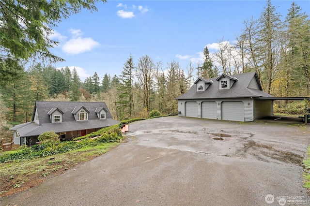 30521 NE 147th Ct, Battle Ground, WA 98604 - view of front of property featuring a detached garage, driveway, a forest view, and a shingled roof
