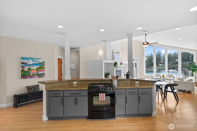 257 3rd Ave, Fox Island, WA 98333 - kitchen with black range with gas stovetop, gray cabinetry, tile counters, light wood finished floors, and recessed lighting