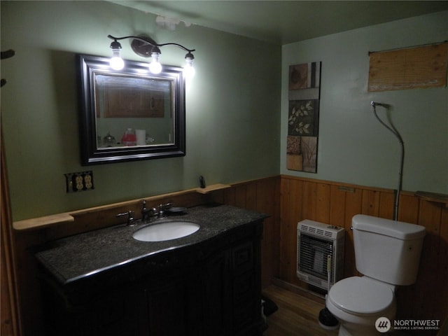 0 High Country Dr W, Tonasket, WA 98855 - bathroom featuring heating unit, wainscoting, toilet, vanity, and wood finished floors