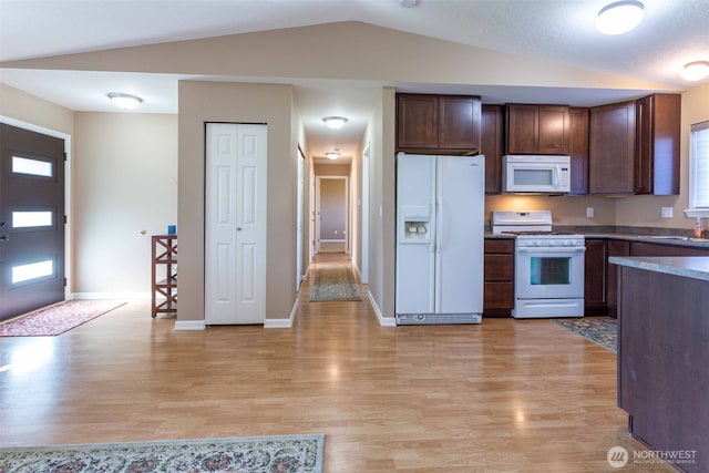 6130 Pacific Heights Dr, Ferndale, WA 98248 - kitchen featuring white appliances, lofted ceiling, light wood-style flooring, dark countertops, and baseboards