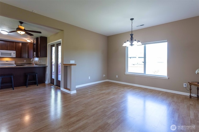 6130 Pacific Heights Dr, Ferndale, WA 98248 - kitchen featuring white microwave, stove, light wood-style flooring, and a chandelier
