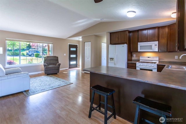 6130 Pacific Heights Dr, Ferndale, WA 98248 - kitchen featuring white appliances, a sink, open floor plan, vaulted ceiling, and light wood-style floors