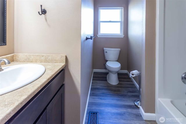 6130 Pacific Heights Dr, Ferndale, WA 98248 - full bathroom featuring vanity, toilet, wood finished floors, a tub, and baseboards