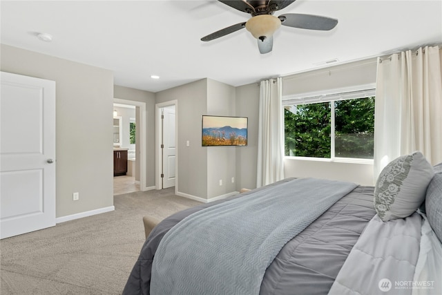 carpeted bedroom with baseboards, a ceiling fan, and ensuite bathroom