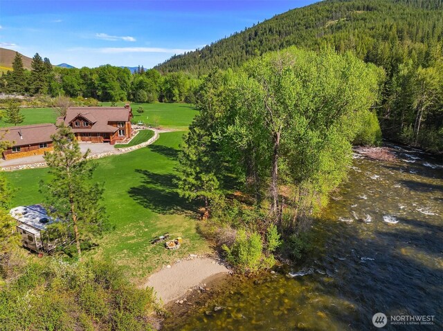 view from above of property with a mountainous background and a forest