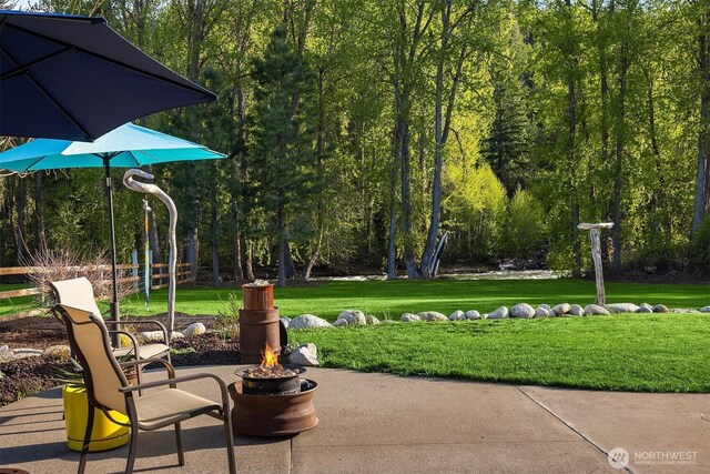 surrounding community featuring a lawn, an outdoor fire pit, and a patio