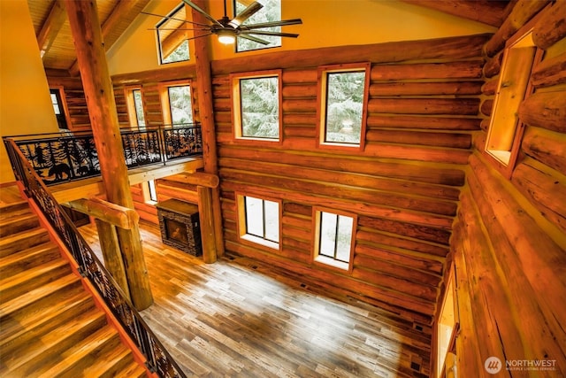 31314 555th Street Ct E, Ashford, WA 98304 - staircase with ceiling fan, wood finished floors, high vaulted ceiling, beamed ceiling, and rustic walls