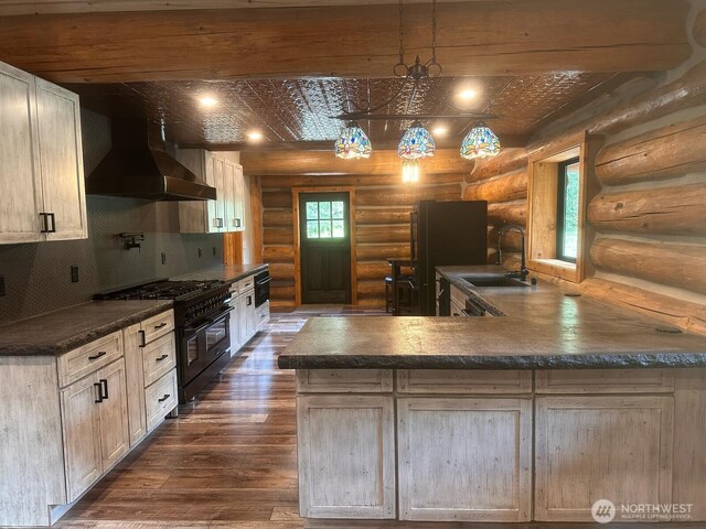 31314 555th Street Ct E, Ashford, WA 98304 - kitchen featuring double oven range, a sink, log walls, wall chimney range hood, and dark countertops