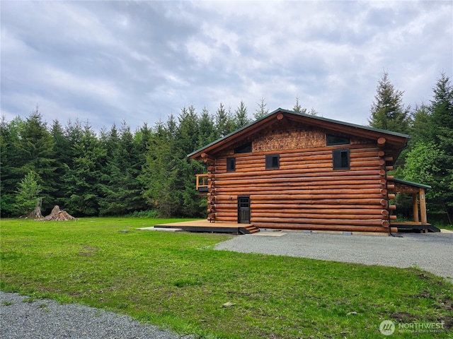 31314 555th Street Ct E, Ashford, WA 98304 - view of side of home with log siding, a wooden deck, and a yard