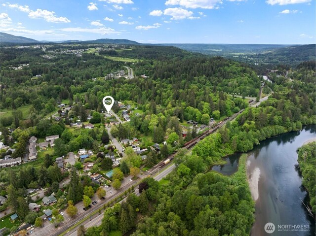 aerial view of a heavily wooded area and a water and mountain view