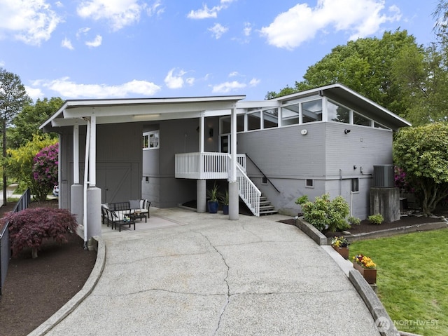 rear view of house featuring cooling unit, a patio, and a sunroom