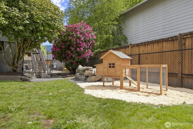 view of yard featuring exterior structure, stairway, and an outdoor structure