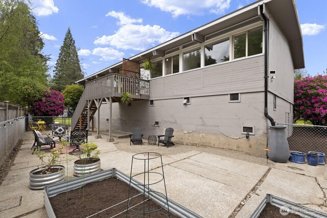 rear view of house with stairs, fence, a patio, and a deck