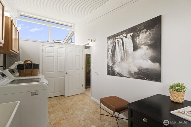 laundry room featuring washing machine and clothes dryer and cabinet space