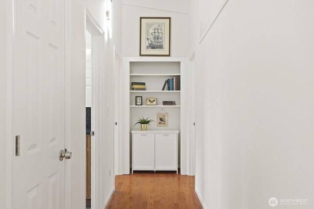 hallway featuring wood finished floors and built in features