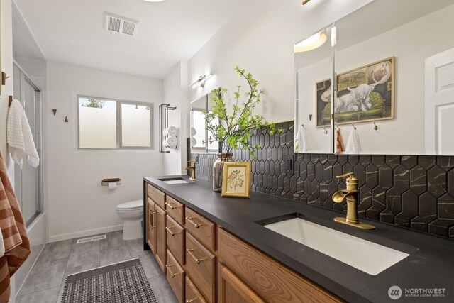 full bath with decorative backsplash, toilet, and double vanity