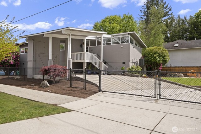 view of front of property featuring a gate, a fenced front yard, driveway, and stairway