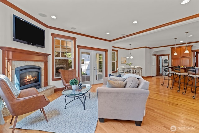13514 95th Ave NE, Arlington, WA 98223 - living room with stacked washing machine and dryer, light wood-type flooring, recessed lighting, a fireplace, and crown molding