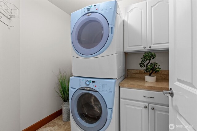 13514 95th Ave NE, Arlington, WA 98223 - laundry room featuring stacked washer and clothes dryer, cabinet space, and baseboards