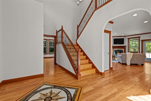 13514 95th Ave NE, Arlington, WA 98223 - stairs with arched walkways, wood finished floors, baseboards, a glass covered fireplace, and recessed lighting