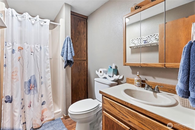 2219 W Pioneer Ave, Puyallup, WA 98371 - bathroom with toilet, a shower with shower curtain, wood finished floors, vanity, and a textured wall