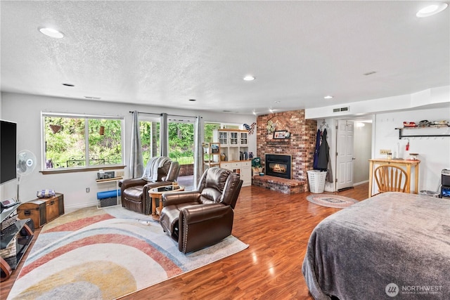 2219 W Pioneer Ave, Puyallup, WA 98371 - bedroom featuring multiple windows, wood finished floors, recessed lighting, a fireplace, and a textured ceiling
