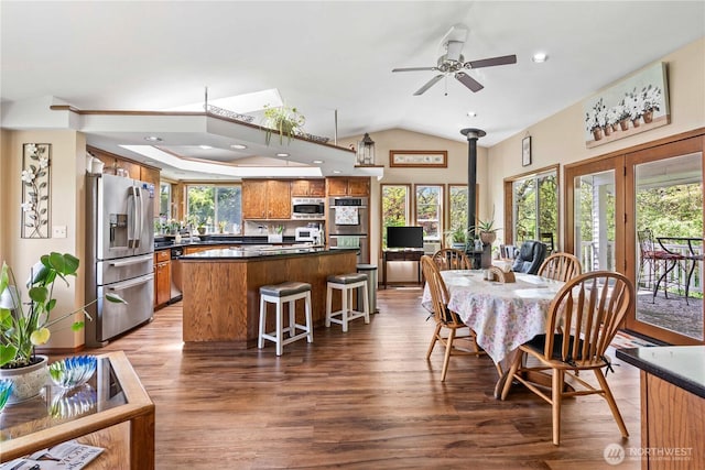 2219 W Pioneer Ave, Puyallup, WA 98371 - dining space featuring a wood stove, wood finished floors, a ceiling fan, and lofted ceiling