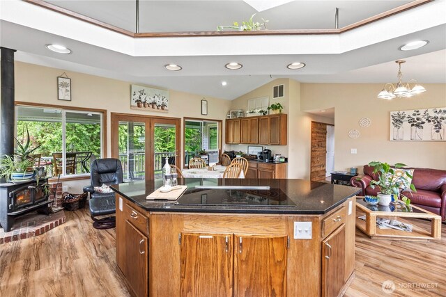 2219 W Pioneer Ave, Puyallup, WA 98371 - kitchen featuring a wood stove, black electric stovetop, light wood finished floors, brown cabinetry, and recessed lighting