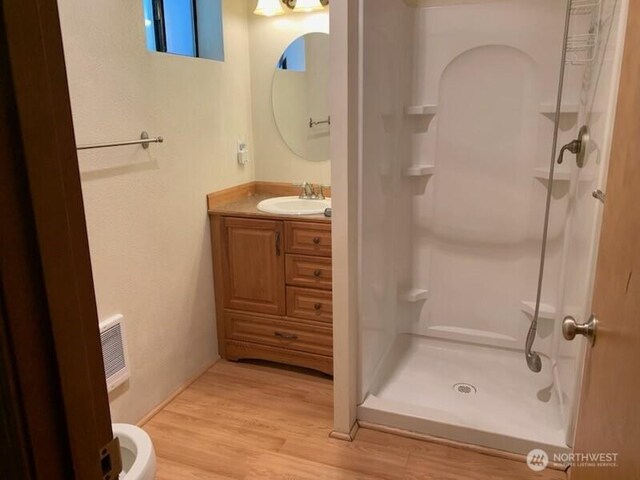 2219 W Pioneer Ave, Puyallup, WA 98371 - bathroom with a stall shower, wood finished floors, and vanity