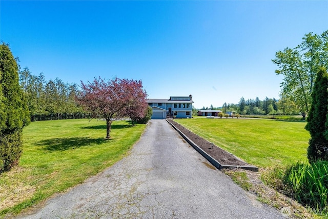view of front facade with a front yard and asphalt driveway