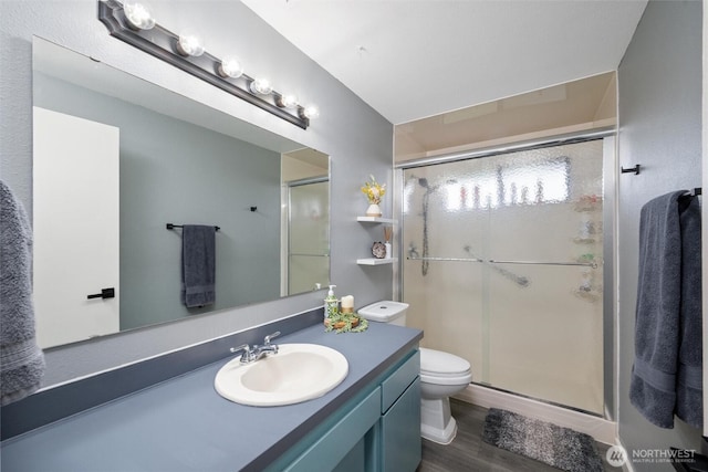 full bath with a shower stall, vanity, and wood finished floors