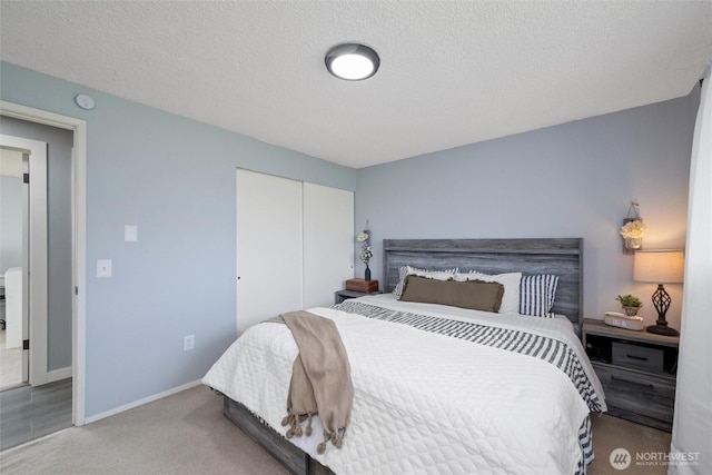 bedroom with a closet, baseboards, carpet flooring, and a textured ceiling