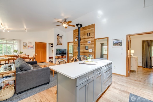 7537 Canyon View Dr, Glacier, WA 98244 - kitchen with gray cabinets, a wood stove, open floor plan, a ceiling fan, and a center island