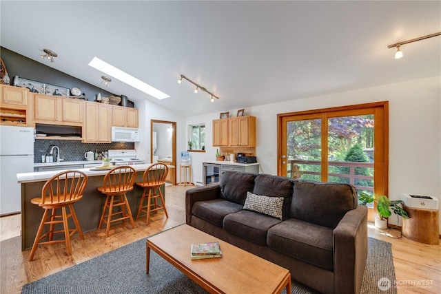 7537 Canyon View Dr, Glacier, WA 98244 - living room with track lighting, a skylight, vaulted ceiling, and light wood-style floors