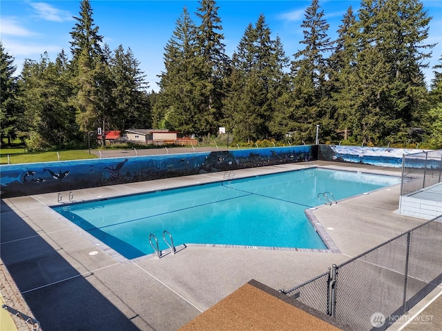 community pool with fence and a patio