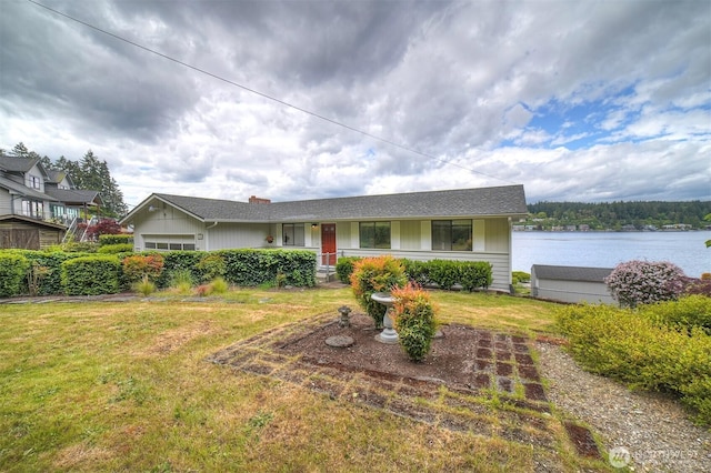 ranch-style house with a front lawn and a water view