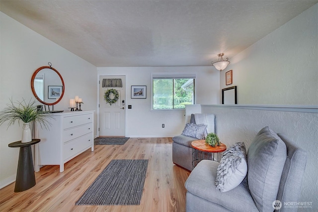 living area with light wood-style flooring and baseboards