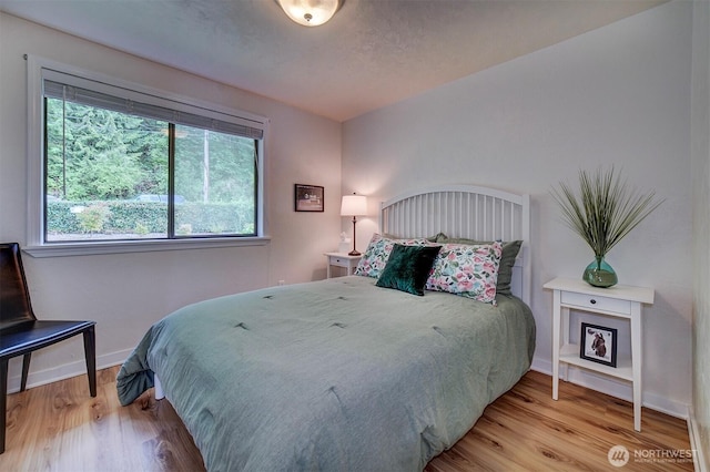 bedroom featuring wood finished floors and baseboards
