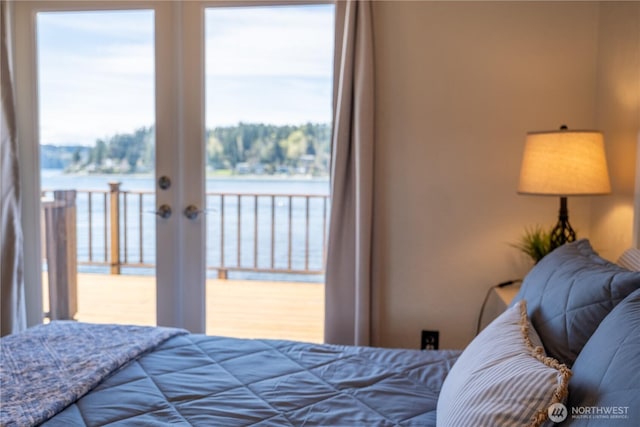 bedroom featuring a water view, access to exterior, and french doors