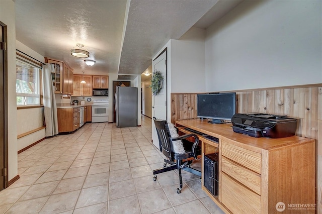 office space with wainscoting, light tile patterned flooring, a textured ceiling, and wood walls