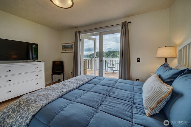 bedroom with access to exterior, wood finished floors, and french doors