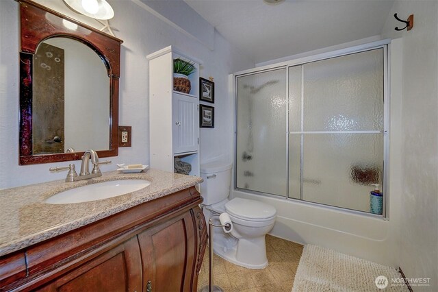 bathroom with vanity, toilet, shower / bath combination with glass door, and tile patterned flooring