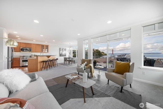 living room with recessed lighting, baseboards, crown molding, and light carpet