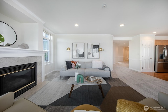 living area with baseboards, recessed lighting, a tile fireplace, and crown molding