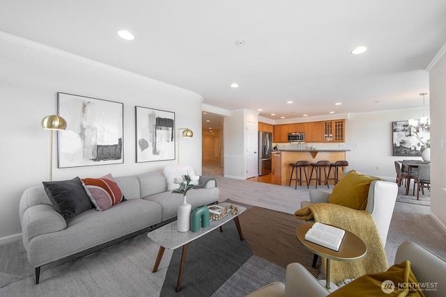 living area with recessed lighting, ornamental molding, baseboards, and a chandelier