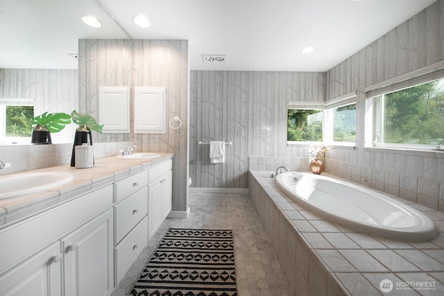 full bathroom with a bath, double vanity, and tile patterned flooring